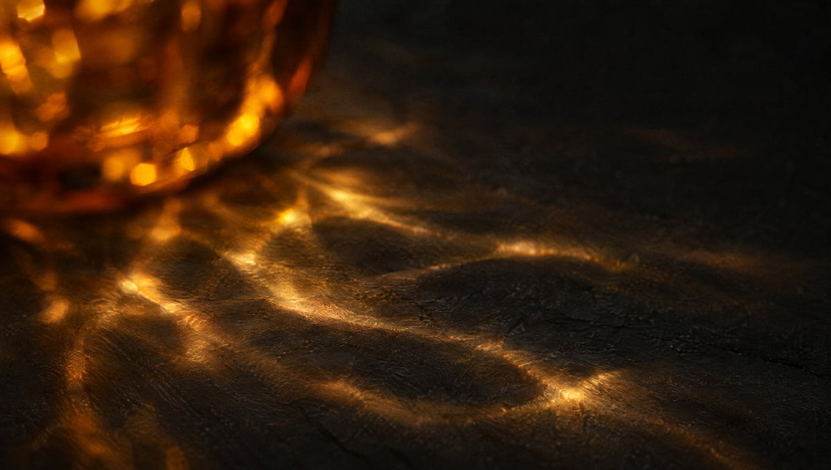 Warm light through amber glass on dark slate